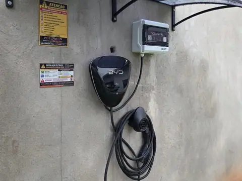 Wallbox BYD instalado na parede com quadro de proteção e placas de orientação