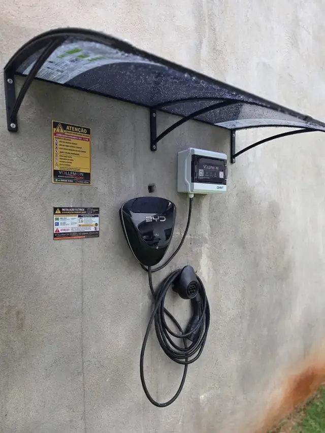 Wallbox BYD instalado em parede externa com quadro de proteção CHINT e cobertura sobre o carregador