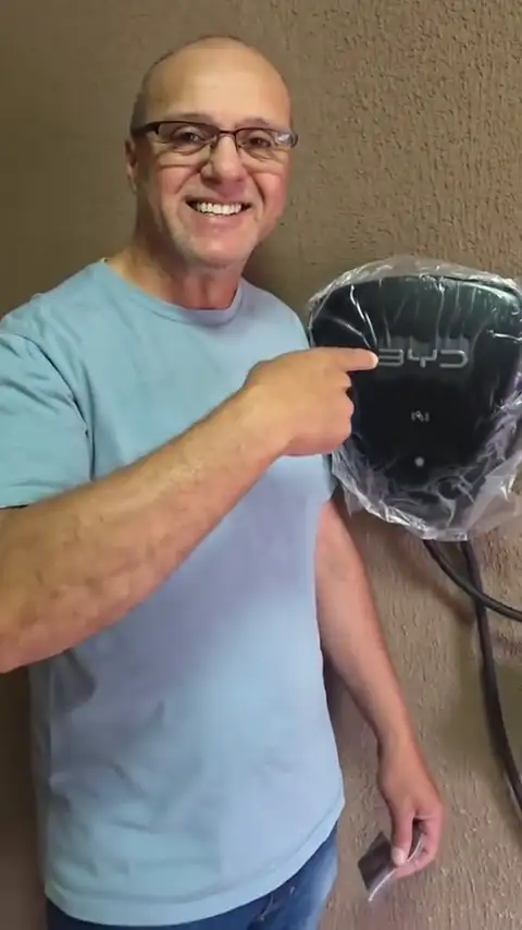 Cliente da Vollfman mostrando o wallbox BYD na garagem